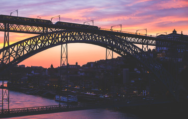 Beautiful super wide-angle summer aerial view of Porto, Portugal, with Douro river and famous view of Dom Luis I Bridge in Porto skyline and scenery beyond the old town, during the sunset