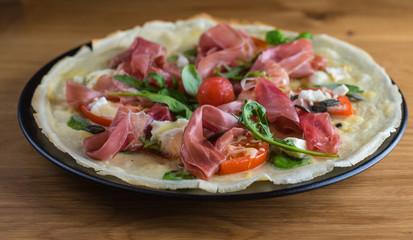 Pizza with prosciutto and cherry tomato