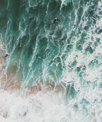 View of Praia do Guincho, Guincho beach, a popular Atlantic Ocean beach on Portugal's Estoril coast, municipality of Cascais, with surfers surfing on the waves, shot from drone