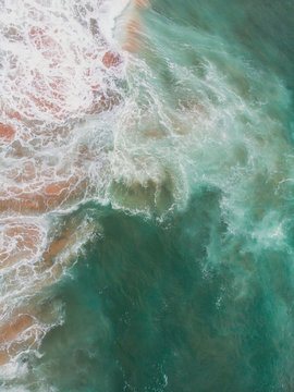 View of Praia do Guincho, Guincho beach, a popular Atlantic Ocean beach on Portugal's Estoril coast, municipality of Cascais, with surfers surfing on the waves, shot from drone
