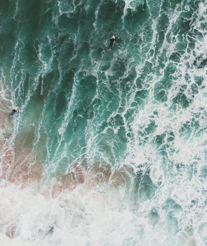 View of Praia do Guincho, Guincho beach, a popular Atlantic Ocean beach on Portugal's Estoril coast, municipality of Cascais, with surfers surfing on the waves, shot from drone