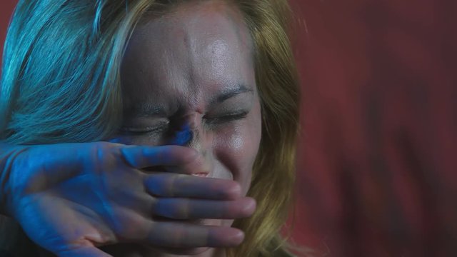 4k, slow motion, Halloween. tired woman in the costume of a terrible witch, erases the make-up from her face with her hands. close-up