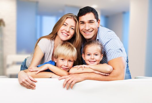 Beautiful smiling family in room on couch