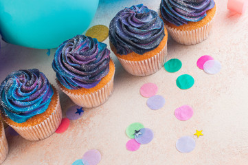 Top view of cupcakes with galaxy whipped cream on party background