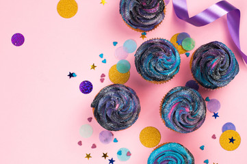 Cupcakes with dark whipped cream on pink background