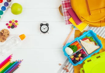Crédence de cuisine en verre imprimé Gamme de produits Boîte à lunch sur fond en bois blanc près des accessoires scolaires et du sac à dos