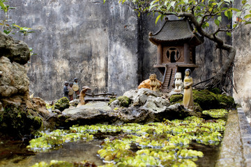 Small porcelain statues in Bonsai scene