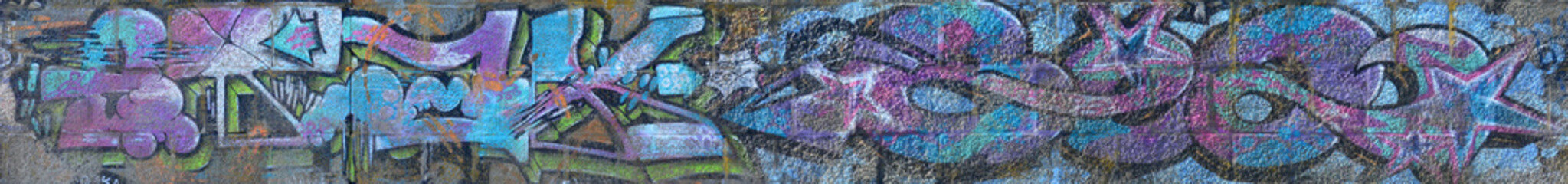Fragment of graffiti drawings. The old wall decorated with paint stains in the style of street art...
