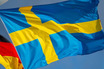 The Swedish flag and the German flag in the background