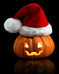 Single orange pumpkin Jack-o-lantern with Christmas Santa hat