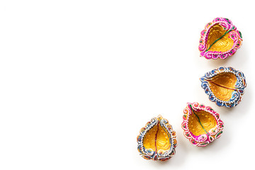 Happy Diwali - Clay Diya lamps lit during Dipavali, Hindu festival of lights celebration. Colorful traditional oil lamp diya on white background