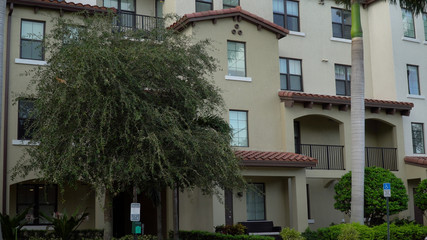 Day time exterior establishing shot of generic apartment or condominium building facade on street level. Southwest USA architecture style in southern location