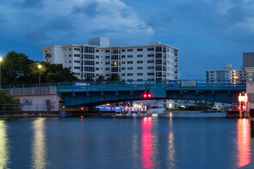 Night time long exposure of boat passing under drawbridge in generic Florida USA coastal city....