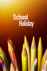 Concept of School holiday  with inscription, color pencils on black background with flare. .