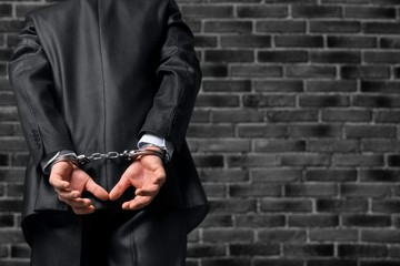 Cropped image of male hands in handcuffs