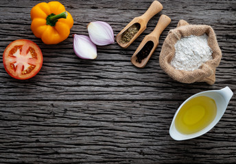 The ingredients for homemade pizza on shabby wooden background.
