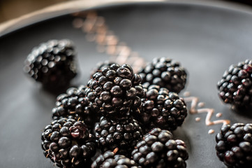 large juicy blackberry berries on a ceramic plate