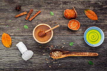 Composition of nature spa ingredients on the dark wooden table. Spa and wellness with dried indian bael ,herbal compress ball,turmeric,cinnamon powder ,cinnamon sticks ,aromatic oil and star anise.