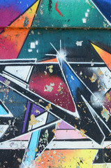 Fragment of graffiti drawings. The old wall decorated with paint stains in the style of street art culture. Multicolored background texture