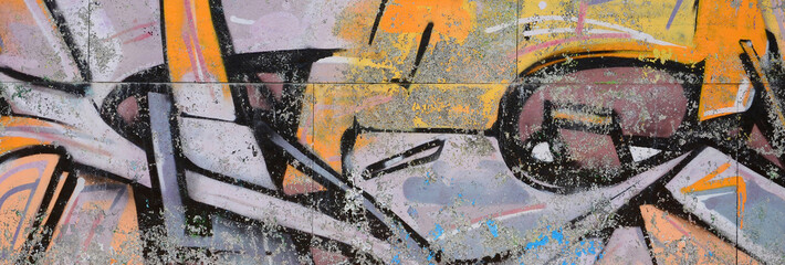Naklejka premium Fragment of graffiti drawings. The old wall decorated with paint stains in the style of street art culture. Colored background texture in warm tones