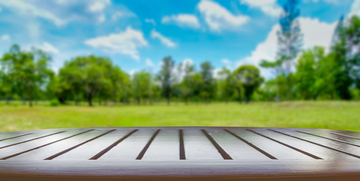 Fototapeta Wooden tabletop with green park nature blurred background