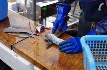 魚を三枚おろしする店員