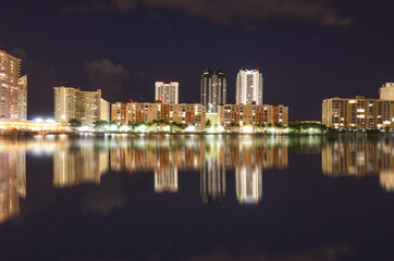 Fototapeta na wymiar Night scene of Miami Skyline with reflections in the canal