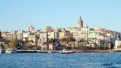 Istanbul, Turkey - October 15, 2017: Camera still view of distant Galata Tower across water channel on sunny day
