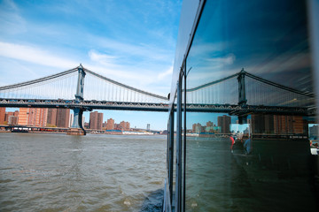 reflection on ferry and brooklyn bridge
