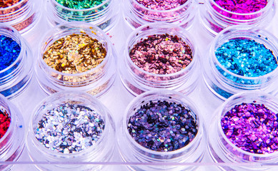 Multi-colored Sequins for the design of nails in a box. Glitter in jars. Foil for nail service. Photo set. Sparkling beauty shimmer, glitter.
