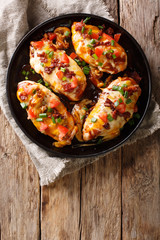 Chicken breast baked with monterey cheese and cheddar, bacon, tomatoes and barbecue sauce close-up. Vertical top view