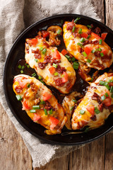 Delicious Monterey chicken breast baked with cheese, bacon, tomatoes and barbecue sauce close-up....