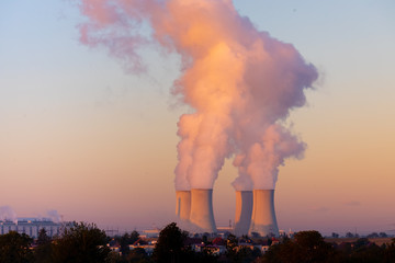 cooling towers with water steam in morning light, nuclear plant