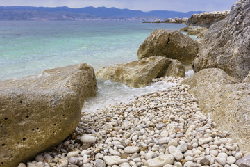 background image of rocky seashore on different Islands of Greece, Rhodes, KOs, Santorini,...