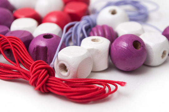 closeup of purple wooden beads on white background