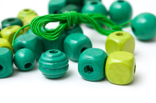 closeup of green wooden beads on white background