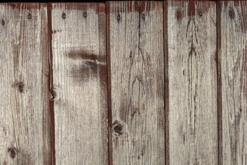 background old faded and cracked wooden boards of brown color faded from the sun