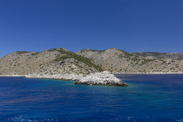 background image of rocky seashore on different Islands of Greece, Rhodes, KOs, Santorini, Halkidiki, Crete, Simi, Corfu