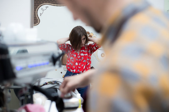 Girl in red printed blouse sitting in cafe