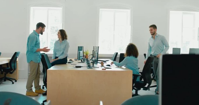 LR DOLLY WIDE office workers communicating together and discussing a projects in busy office. 4K UHD 60 FPS SLOW MOTION