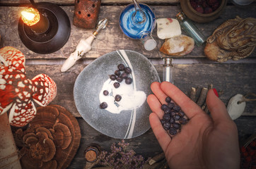 Witch woman is preparing a magic potion on paranormal table background. Witchcraft concept.