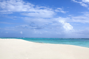 White sand beach, blue sea and sky with clouds background