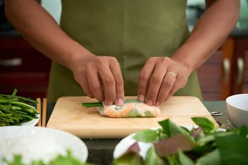 Foto op Canvas Man making traditional Asian spring rolls with shrimp and vegetables © DragonImages