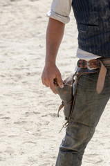 wild west cowboy taking his pistol out of the holster