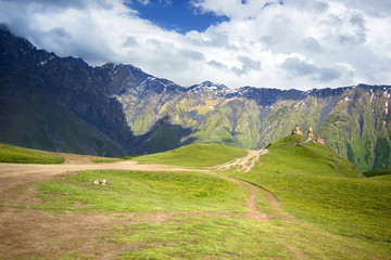 Fototapeta premium Gergeti Trinity Church, Tsminda Sameba on the hill on Kazbek mountain background in Georgia