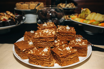 Candy bar for birthday or wedding celebration. Chocolate homemade cake with walnut in the top. Tasty sweet food on the table.