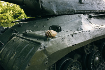 Old flask is lying on the USSR tank from the Second World war. Armored fighting vehicle as a memory...