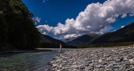 Anonymous man standing on river coast