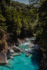 Clear river between cliffs with forest