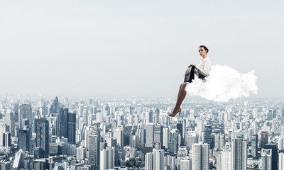 Fototapeta na wymiar Businesswoman or accountant on cloud floating high above modern 